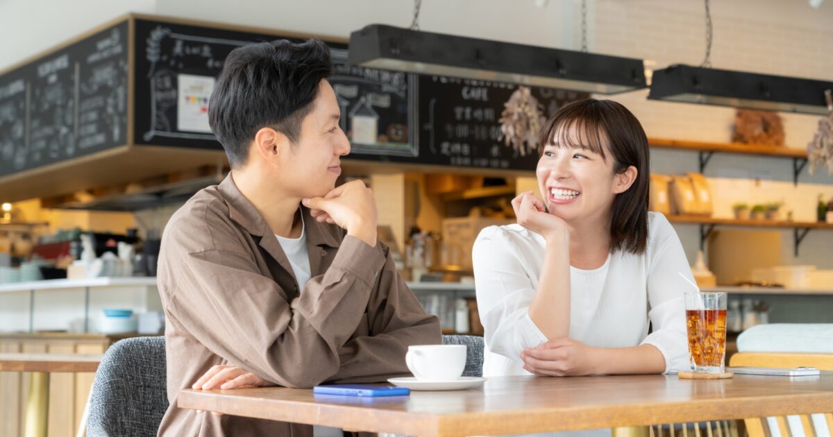 カフェで向かい合って会話を楽しむ若いカップル