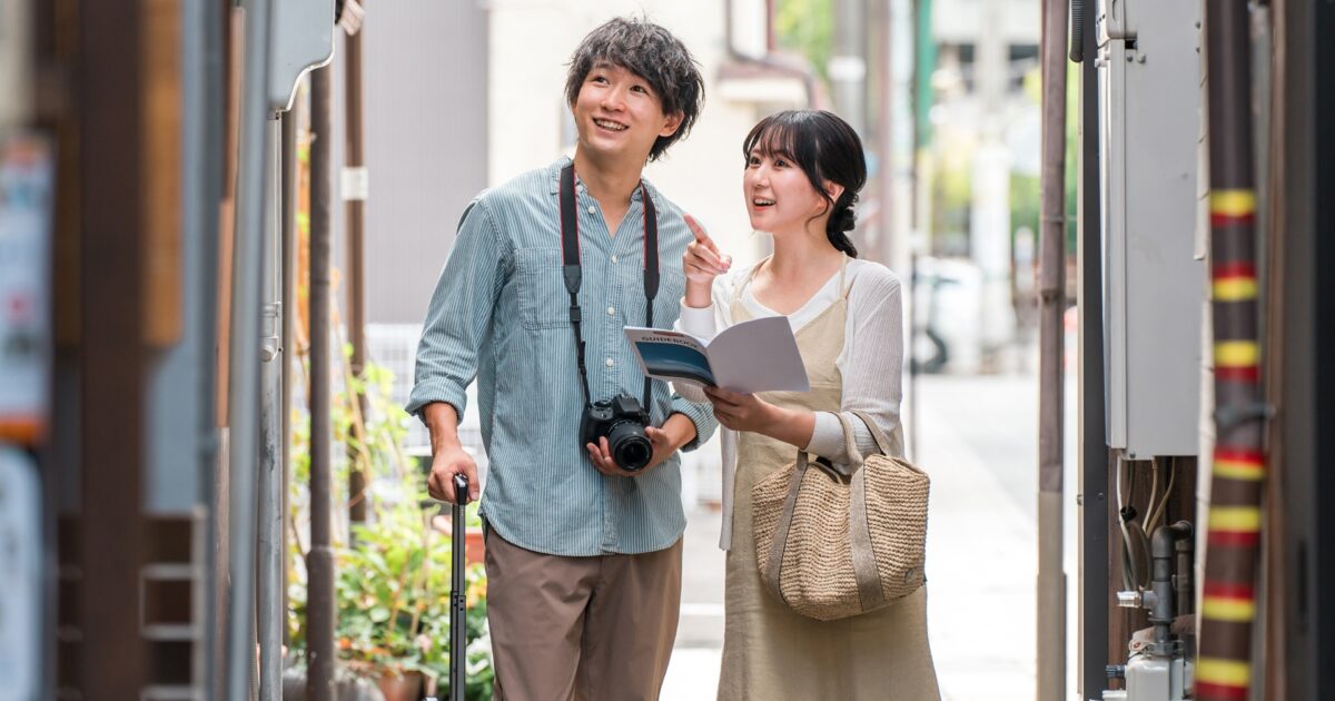 観光地で地図を見ながら歩く旅行中のカップル