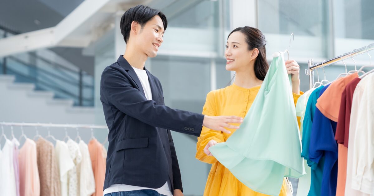 ショップで服を見ながら相談する仲良しカップル
