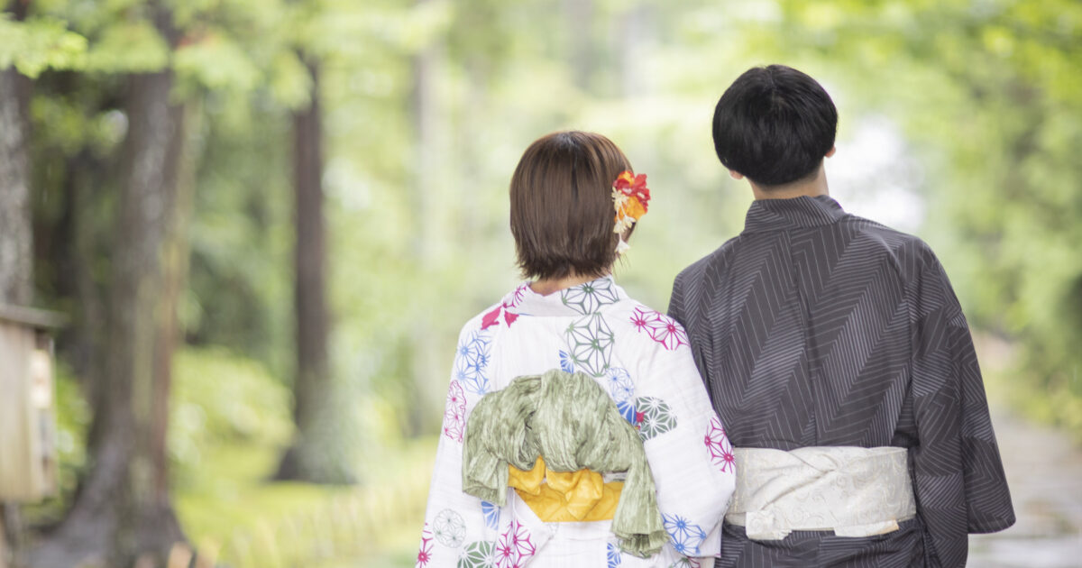 浴衣姿で並んで歩くカップルの後ろ姿