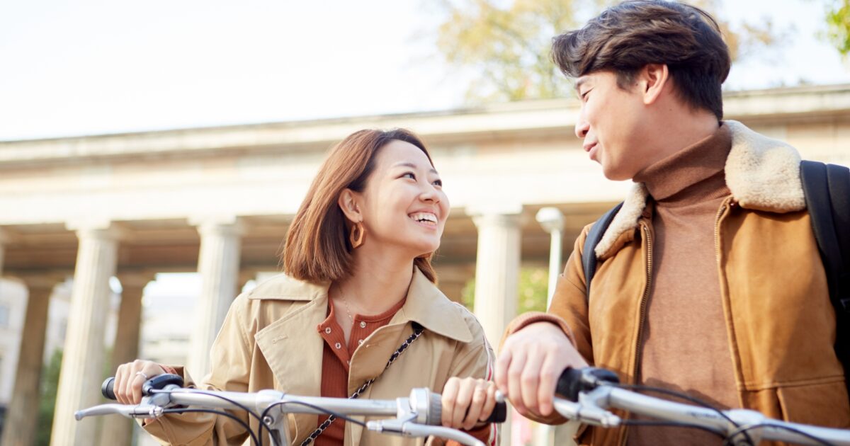 自転車を押しながら会話を楽しむ秋のカップル