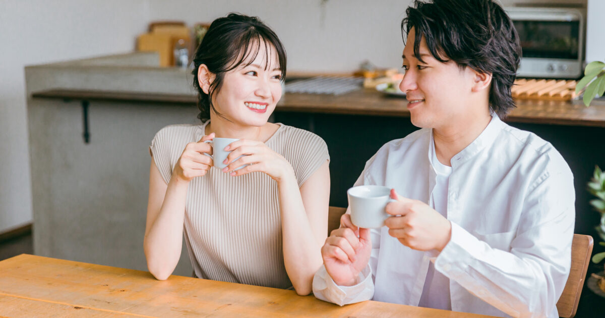 カフェでコーヒーを飲みながら会話するカップル