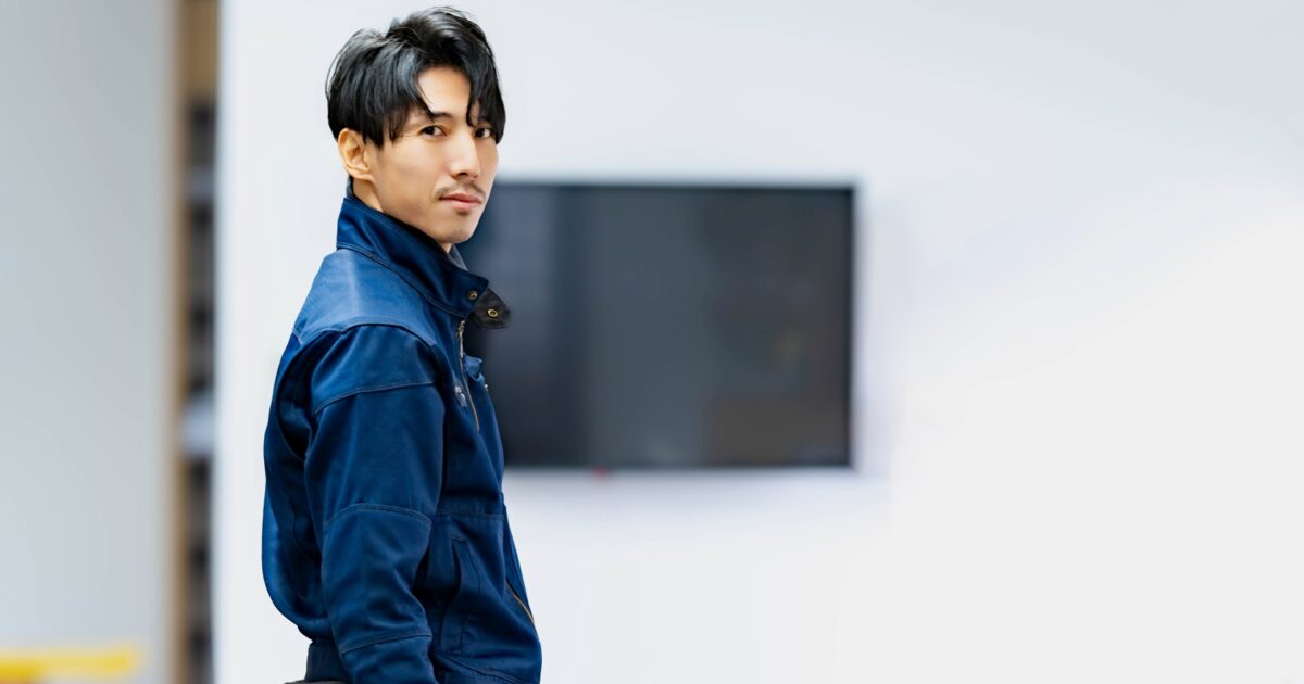 作業服を着て振り返る現場作業員の男性