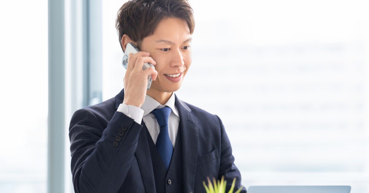 スマートフォンで通話中のスーツ姿の若い男性