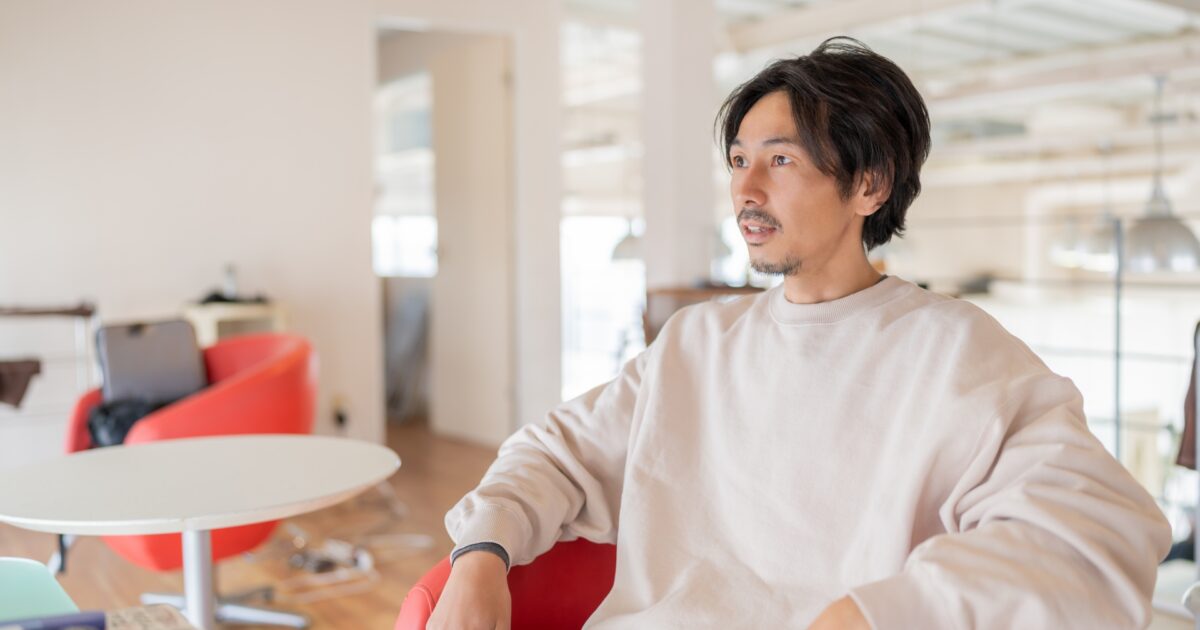 カジュアルな服装で椅子に座るリラックスした男性