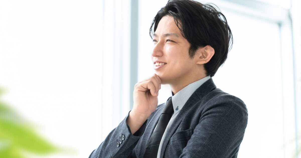 ビジネスマンが笑顔で考え事をするポートレート