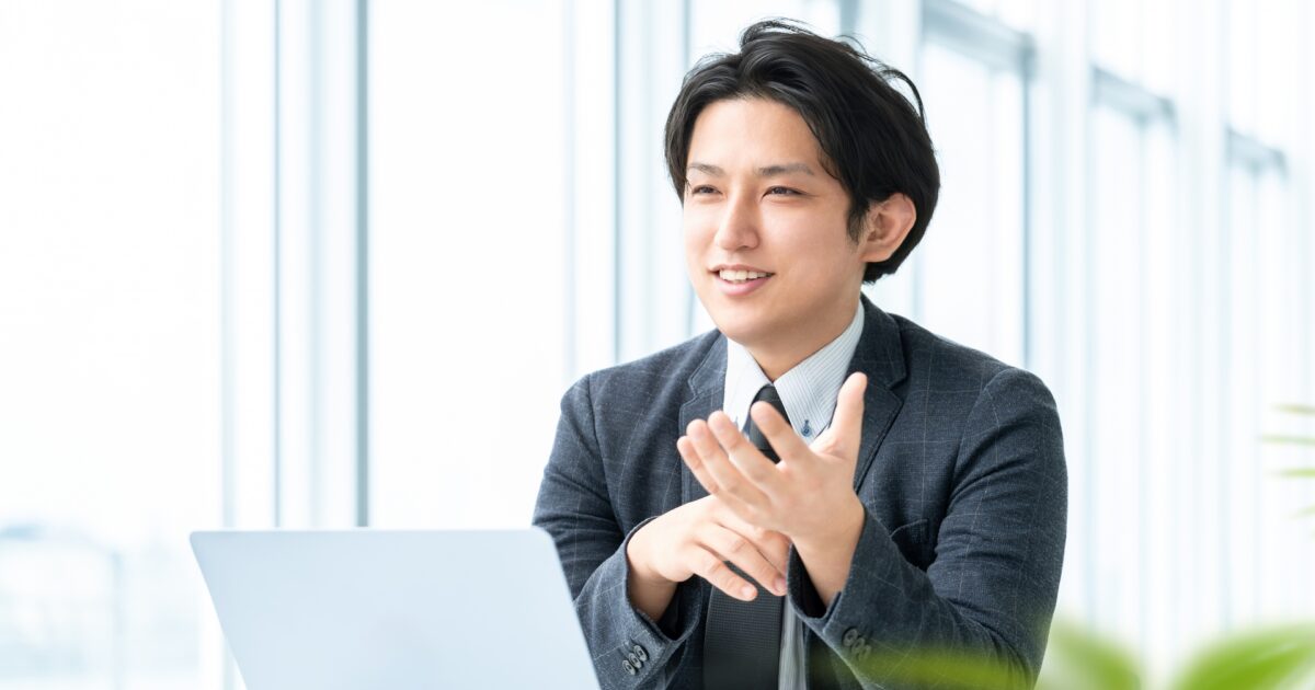 ノートパソコンを前に話すビジネスマンの打ち合わせシーン